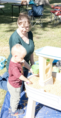 LITTLE FREDERICK BAUGHMAN digs into the fun at the Corn Dig, while his mom, Lyndsey Baughman, looks on during this year’s Pumpkin Patch Festival in Stockton.