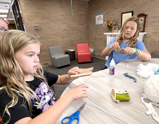 KINSLEY RUDMAN and Book Club leader Carsen Balthazor during the Warriors Book Club making yarn cats.