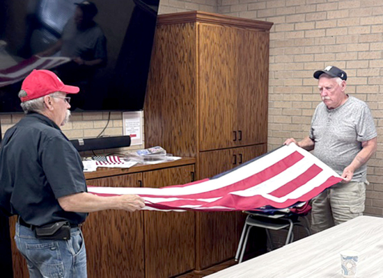 WES CARMICHEAL and Dave Anderson Folding the American Flag during Adult Social/Coffee time Tuesday.
