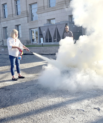 JENNY REICHARD takes her turn learning how to use a fire extinguisher during the safety training held at the Rooks County Courthouse on Wednesday, October 7th.