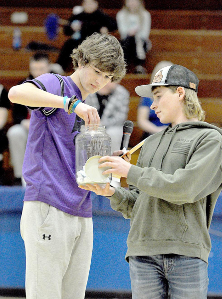 STUCCO MEMBERS Max Moffet (left) and Hayden Hilbrink draw to see which three individuals will shoot the half-court shot during halftime of the Lady Tigers’ game against Phillipsburg. The fundraising effort was enjoyed by all with Don Moffet, agent for Farm Bureau Financial Services, giving away $50 for a made shot.