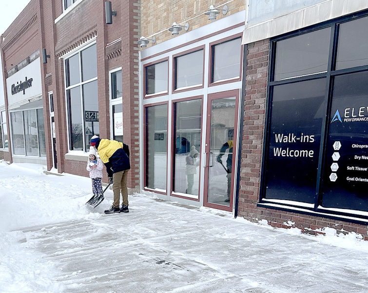 KOLT NEWELL OF ELEVATE………, a local chiropractor, was busy clearing sidewalks in front of his business in Plainville late Saturday afternoon. His work was being supervised by his daughter, Stella, who just might have had to sample a bit of the fluffy stuff. Hmmm, maybe Dr. Newell has some tips about shoveling snow safely. (Submitted Photo)