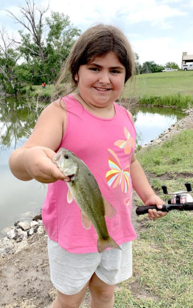 EMILEE BROWN shows off her Largemouth Bass she caught at the event.