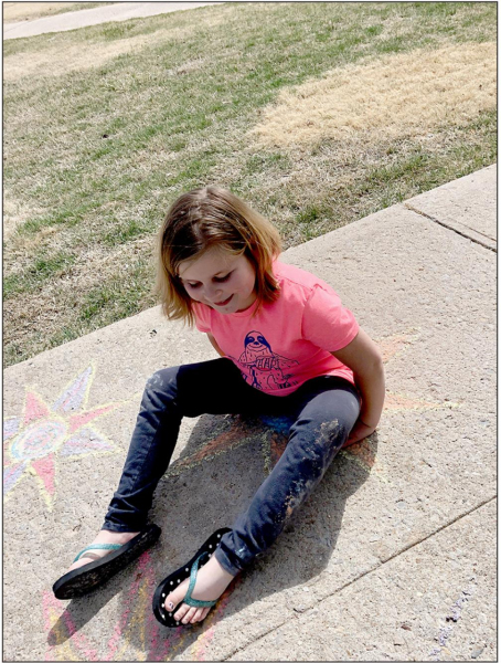 SHONI JONES works on one of her sidewalk chalk pictures she drew around town for people to enjoy during the social distancing because of the COVID-19 pandemic.
