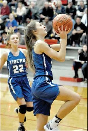 WITH TATUM HAMILTON trailing her, Shae Griffin goes in for a layup, scoring two of her 17 points in the game against Hill City.