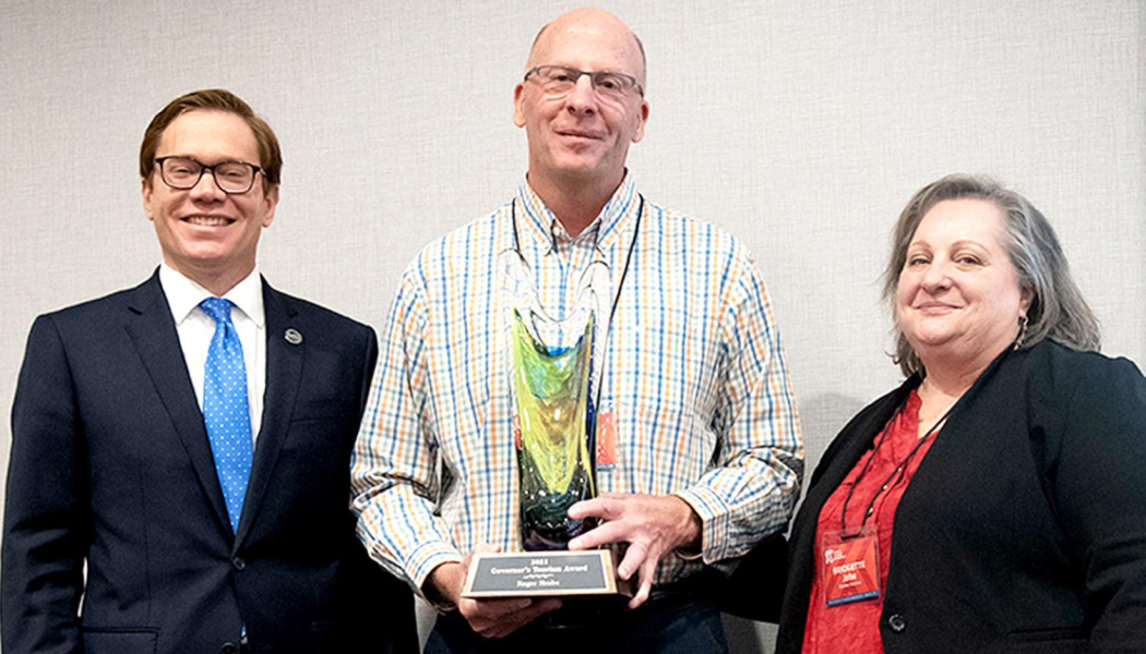 ROGER HRABE, Rooks County Economic Development Director, received this year’s Governor’s Tourism Award October 20th during the Kansas Tourism Conference held October 18-20 in Liberal. Presenting the award to Roger included Lieutenant Governor and Commerce Secretary David Toland, left, and Bridgette Jobe, the Director of the Kansas Tourism Division at the Kansas Dept. of Commerce.