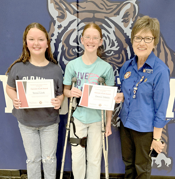 RECEIVING CERTIFICATES OF PATRIOTISM at the Veterans Day program for singing the National Anthem at the Rooks County Free Fair this summer were junior high students Tessa Look and Omree Dibble, who are pictured with VFW Auxiliary President Deb Niermeier.