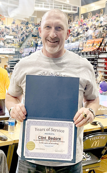 CLINT BEDORE, head wrestling coach at Stockton High School, was presented a certificate from Kansas Wrestling Coaches Association president Nathan Broeckelman at the 3-2-1A State Wrestling Championships held last Friday and Saturday in Hays. Bedore was recognized for his 15 years of service to the sport of wrestling. He was the coach at Nickerson for one year prior to coming back to Stockton, where he just finished his 14th year of leading the Tigers.