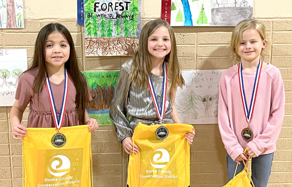 THIRD-GRADE POSTERWINNERS (l to r)—1st, LexiYounger, Plainville; 2nd, Norah Muir, Stockton; and 4th, Karly Dopita, Damar. Third-Place Winner Vanessa Parson, Sacred Heart, is not pictured.