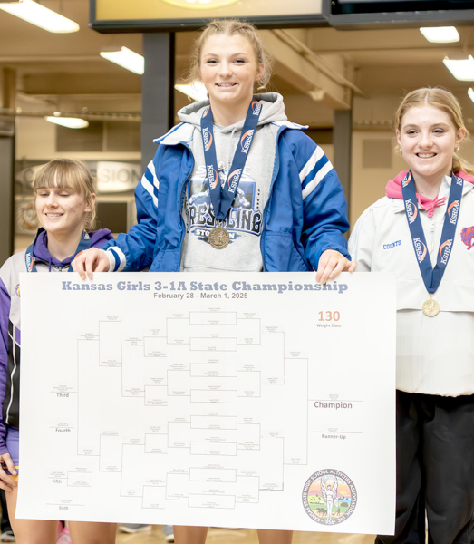 ASHLYN, the 3-2-1A State champion at 130#, stands atop the podium with Annika Dietz (left, 3rd) and Averie Counts (2nd).