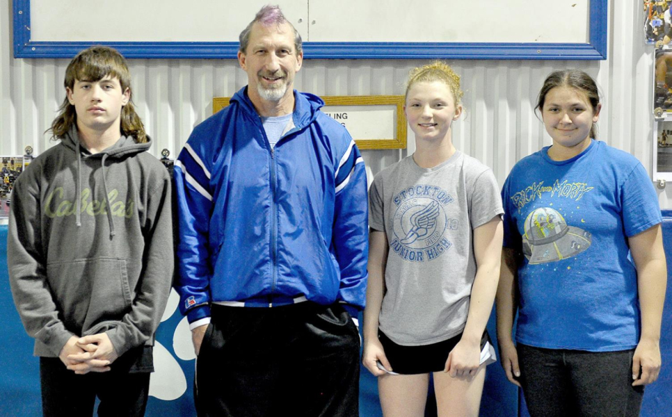 TIGER WRESTLING COACH Clint Bedore’s hairdo for a day came courtesy of his State qualifiers, Emerson Lowry, Ashlyn Hahn and Raven Long, who did some fine work with the clippers and dye!