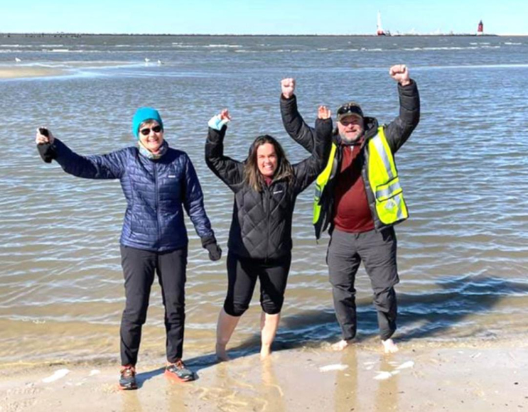 IN THE PICTURE ABOVE, Linnea Dietrich (Erin’s mother), Erin, and Chris dip their toes in the water of the Atlantic Ocean, March 3rd, as they prepare to leave Cape Henlopen, Delaware, for their walk across America. BELOW, Erin and Chris celebrate their finish in the waters of the Pacific Ocean, October 20, with the Golden Gate Bridge barely visible through the fog behind them.