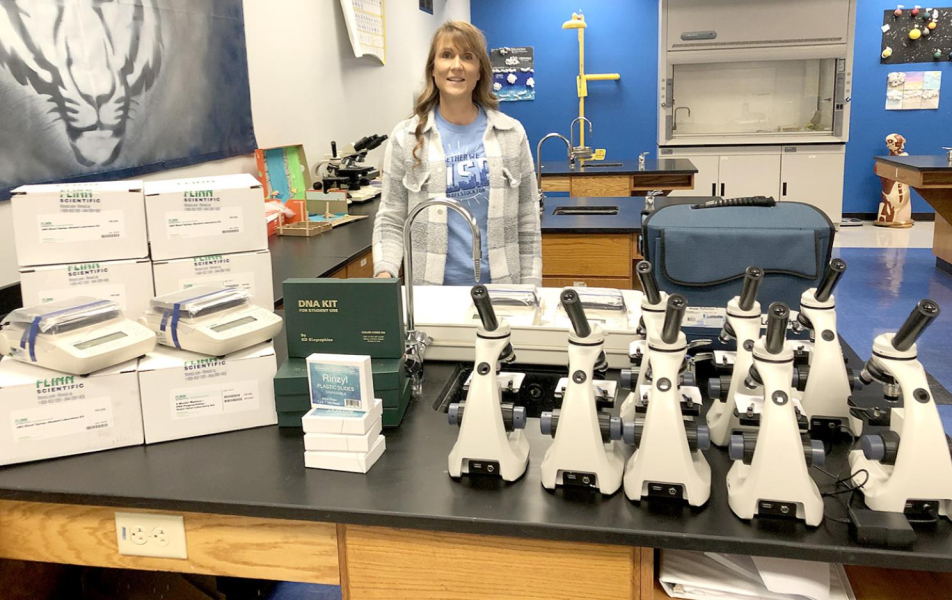 JANET KUHLMANN, science instructor at USD 271, is shown with science equipment purchased through the Ken and Ann Currie Memorial.