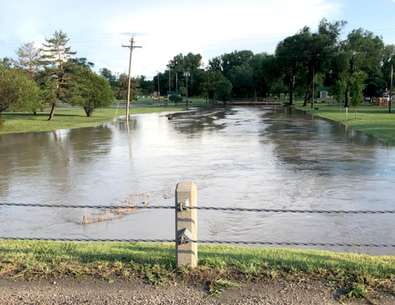 THIS PHOTOGRAPH, taken around 8:30 Monday morning, shows Dibble Creek at the Lower City Park. The lower park was completely underwater Sunday night before having receded somewhat the next day.