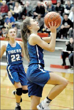 WITH TATUM HAMILTON trailing her, Shae Griffin goes in for a layup, scoring two of her 17 points in the game against Hill City.