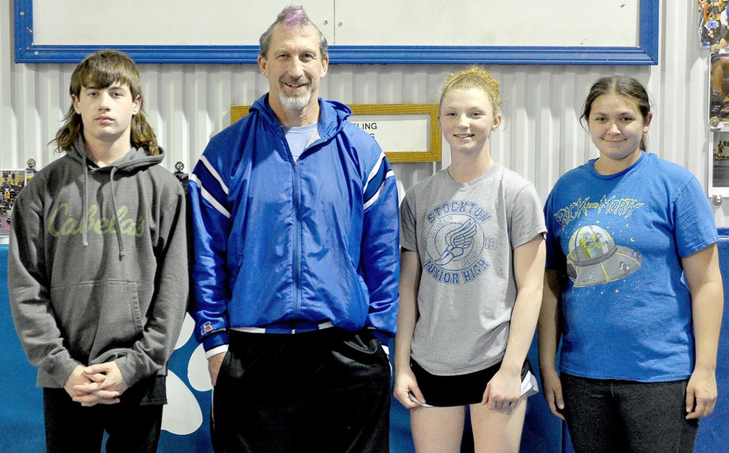TIGER WRESTLING COACH Clint Bedore’s hairdo for a day came courtesy of his State qualifiers, Emerson Lowry, Ashlyn Hahn and Raven Long, who did some fine work with the clippers and dye!