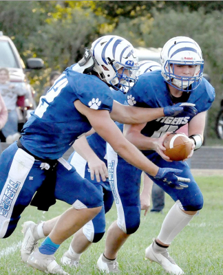 QUARTERBACK TROY ROGERS fakes a handoff to his teammate, Rylan Basart (left) during action in the Tigers’ game against Logan/ Palco on Friday in Stockton.