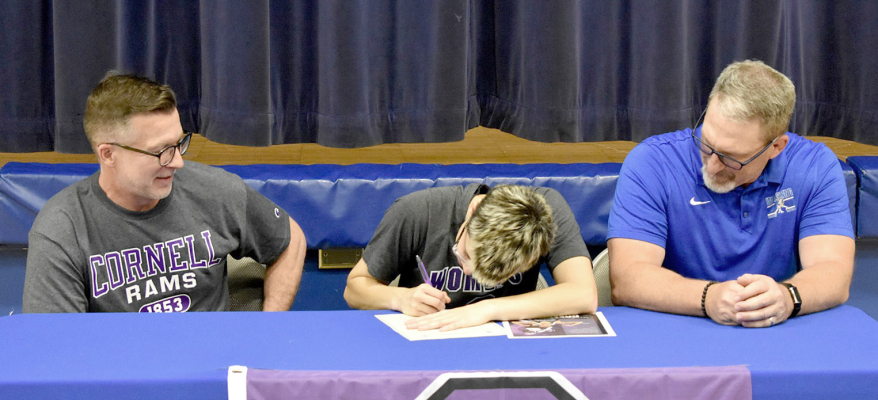 CAROLINA NORTHUP signs her intent to wrestle at Cornell College last Friday afternoon, while her father, Tabor Northup (left), and coach Clint Bedore proudly look on. (Courtesy Photo)