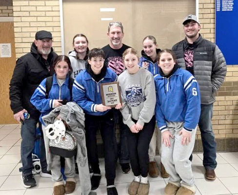 THE STOCKTON TIGER GIRLS WRESTLING TEAM proudly displays the third-place team plaque they earned at the Nickerson Invitational held last Friday. From left are: Coach Justin Basart, Serenity Carpenter, Kourtnie Bird, Carolina Northup, Coach Clint Bedore, Saj Snyder, Temprance Northup, Mia Odle, and Coach Deyton Bedore. (Courtesy Photo)