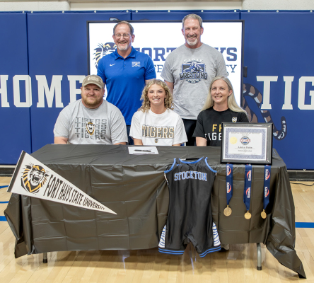 AFTER AN UNDEFEATED SEASON on the mat, Stockton senior Ashlyn Hahn signed a letter of intent on Monday to wrestle at Fort Hays State University this fall. She is pictured with some of her biggest fans, her parents, Travis and Angela Hahn, and her coaches, Justin Basart and Clint Bedore.