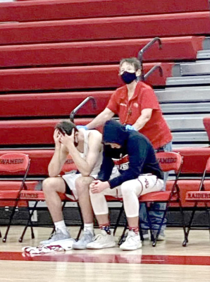 FORMER STOCKTON RESIDENT, Pam Bedore, a janitor at Wamego schools, consoles seniors Tanner Hecht (left) and Jackson White, (right) following their close 4A Substate Championship loss to Holton, 60-56. (Photo Courtesy of Kara White)