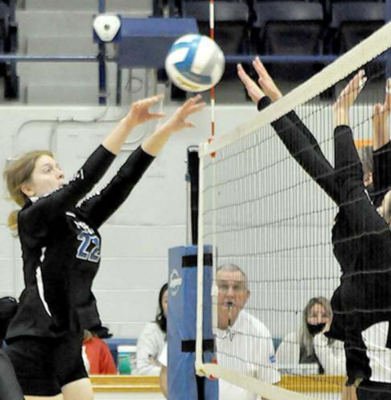 ELIZABETH BUSONIC sets the ball over the net past a Rawlins County defender during sub-state action in Stockton on Saturday.