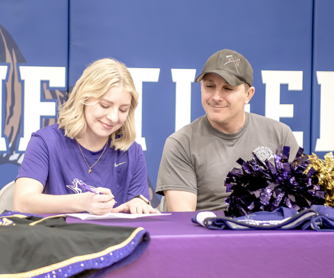 STOCKTON HIGH SCHOOL senior Saj Snyder signed a letter of intent last Thursday to join the Kansas Wesleyan University Dance Team. Pictured on left is Saj signing, while her proud dad, Ian Snyder, looks on. Also sharing in the special moment were several other members of her family. Front row, from left, are Ella Snyder, Saj, and Lyric Snyder; and back row: Jeff Emery, Ian, Jill Emery, and Eli Snyder.