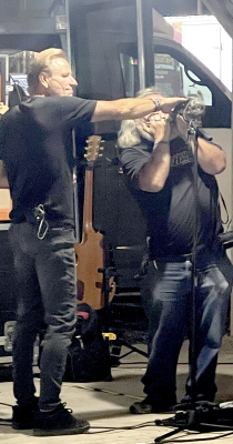 PARAMOUNT, an ‘80s Rock Tribute band allowed Lorin Trowbridge (right), playing his harmonica, to join them during the Rooks County Free Fair’s Friday night concert under the Pavilion. The band’s lead singer, Eddie Light, steadies the dog on his shoulder while Trowbridge plays away.