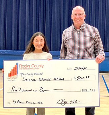 CORBYN GLENDENING OF STOCKTON won this year’s 2025 Youth Entrepreneurship Challenge with her business idea, Social Sparks, Media. Presenting Corbyn with her winning prize money of $500 is Rooks County Economic Development Director Roger Hrabe.