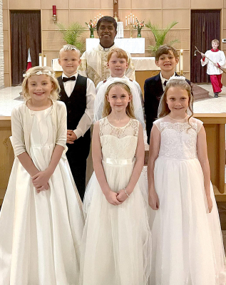 ON SUNDAY,APRIL 26TH, a blessed gathering took place at St. Thomas Parish in Stockton as these young souls received their First Communion, marking a significant step in their spiritual journeys. Pictured are (front row) Waylynn Biggs, Rylie Couse, Ainsley Whitney; (second row) Charles Reed, Fin Larsen, Ned Berkley; and (back row) Father Michael. Orrin Beall, pictured in the background of the photo, was one of the Altar servers for the occasion.
