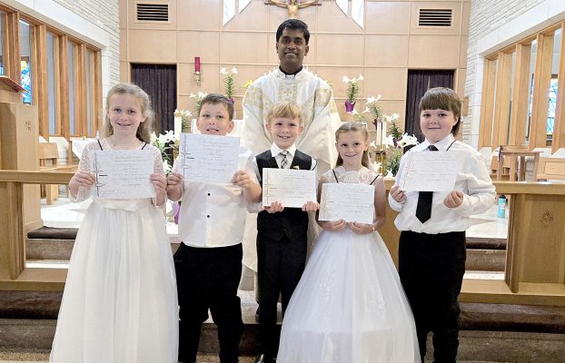 MAKING THEIR FIRST HOLY COMMUNION at St. Thomas Church on Sunday, April 27th were (from left): Finley Peterson, Treyvin Mongeau, Carson Riener, Owen Muir, and Ryker Whitney, with Father Michael as celebrant.