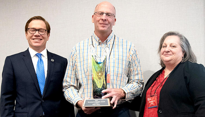 ROGER HRABE, Rooks County Economic Development Director, received this year’s Governor’s Tourism Award October 20th during the Kansas Tourism Conference held October 18-20 in Liberal. Presenting the award to Roger included Lieutenant Governor and Commerce Secretary David Toland, left, and Bridgette Jobe, the Director of the Kansas Tourism Division at the Kansas Dept. of Commerce.