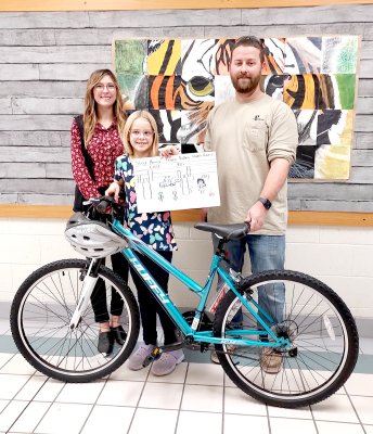 EACH OCTOBER, Prairie Land Electric Coooperative, LLC provides the area third-grade teachers packets to teach students about power line safety and and how to use electricity safely. The students then create posters and the top three winners are awarded a new bike and helmet. Stockton third grade student Makinley Riener was the third-place winner in this year’s Safety poster Contest. She was presented with her bicycle and helmet from Prairie Land lineman Austin Wieden on Tuesday, November 8th. Pictured are M