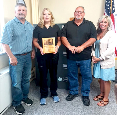 HEALTH NURSE LORI EICHMAN received her 30-year plaque for service to Rooks County at the commission meeting on Tuesday, July 18th. Commissioner John Ruder, Lori Eichman, and commissioners Tim Berland and Kayla Hilbrink are pictured.