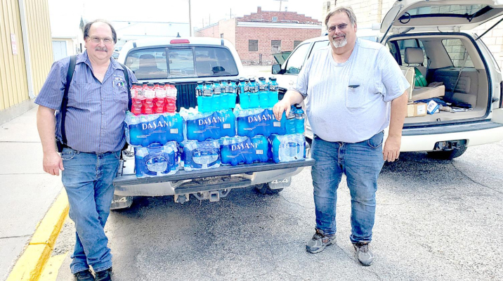 ROOKS COUNTY HEALTH CENTER donated 70 cases of bottled water and 20 cases of fluid replacement drinks such as Gatorade, which were delivered to the five fire departments in Rooks County (Stockton, Woodston, Palco, Damar and Plainville.) Shown here are Bill Dibble, Woodston City Fire Chief and Jon Voss, Stockton City Fire Chief receiving their allotment.
