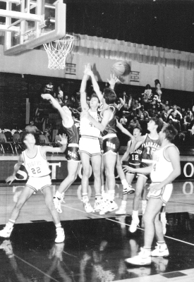 STOCKTON TIGER DARRICK TRIPE drew a swarm of Norton players as he let go with a jump shot at the Downs Round Robin Tournament game played on the Stockton floor held during the first week of December 1989. Dennis Kuhlmann, 22, and Danny Kuhlmann, 34, are also pictured on the court.