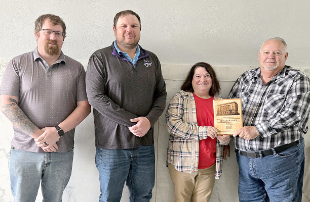 DENA BOUCHEY was presented with an appreciation plaque for her 30 years of service in the Rooks County Treasurer's Office at the Rooks County Commission meeting on Tuesday, April 7th. Pictured are (from left) commissioner Tracy Rudman, commissioner Jake Prockish, Dena Bouchey, and commissioner Tim Berland.