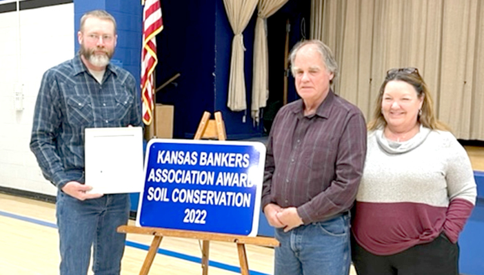 ROD & LISA MARCOTTE, right, who farm in the Palco area, were presented the 2022 Kansas Bankers Association Award at the 75th Anniversary of the Rooks County Conservation District Annual Meeting held Monday, January 30th, at the Stockton High School Gym. Presenting the Marcottes the award is District Supervisor Oliver Beall, pictured left. (Photo Courtesy of Kyleigh Stice)