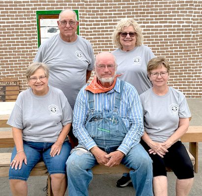 THESE FIVE ORIGINAL BULL CITY OPRY CO. MEMBERS were vital to the success of the group for 30 years and are shown in front of this year’s background of “Hoot ‘N Holler” presented Saturday night, August 24, in Alton, Kansas. This was their last performance due to the retirement of the writer and director, Jo Peterson. Pictured front row, left to right: Mary Hartzler, Rex Johnston, and Beverly Ballard; and back row, from left: Eldon Hartzler and Jo Peterson.