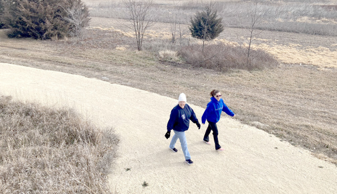 ENTHUSIASTIC FIRST-DAY HIKERS stride on the new trail at Plainville Township Lake January 1, as seen from the archery-stand overlook near the trail’s current end. (Courtesy of Bret Greenwood)