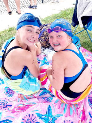 TIGER SHARKS ADDIE DIX ANDTESSA LOOK take a break during the Stockton home swim meet on Saturday, June 1st.