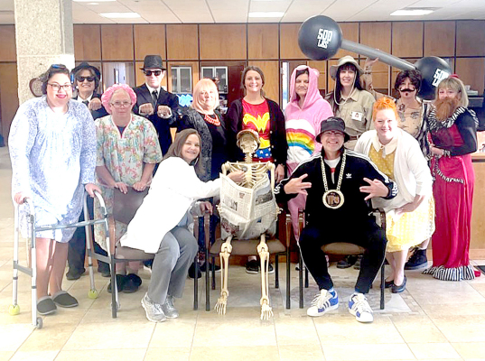 GETTING INTO THE “SPIRIT” OF THINGS at Solutions North Bank on Halloween were (front row, from left): Caitlin Hammond, Stacey Ketelsen, Virginia Look, Mr. Bones, Dale Winklepleck, Amber Rogers; (back row) Diane Voss, Sharri Coffey, Anita Conger, Carissa Brass, Linda Conyac, Ginger Kriley, Angie Johnston and Jackie Spires.