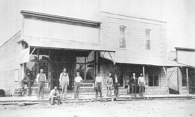 THIS PICTURE shows some of Plainville's businesses circa 1910. The A. H. Posegate Store is on the left, and the one on the right is the Meistrell Grocery Store, with John Meistrell standing out front. The small building to the far right is Foster's Land Office.