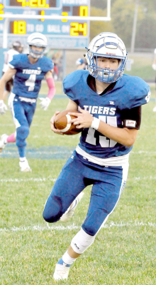 CATCH AND RUN! Jace Hull picks up some valuable yardage after catching a pass in the Tigers’ game with Rawlins Co. last Friday. Also pictured is Kameran Hamel, #4.