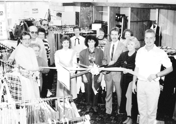 In 1989, Mr. and Mrs. Chris McDonald opened a clothing store in Stockton announcing the venture with a ribbon cutting by the Stockton Area Chamber of Commerce. Pictured are: (from left) Chris Kollman, Dot Hrabe, Bob Brungardt, Clarene and Loren Goodheart, Vicki Novotny, Mrs. Lee Phelps, Karen McDonald, Linda Jones, Chris McDonald, Sally Novotny, Linda Yohon, and Rusty Hrabe.
