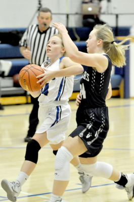 DELANY SNYDER protects the basketball as she goes in hard for a layup during the Stockton vs. TMP contest last Friday.