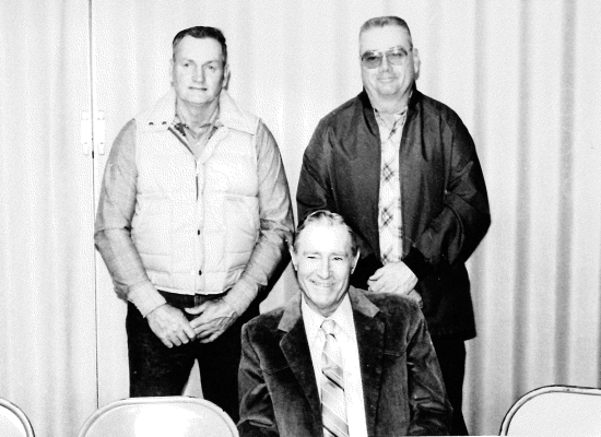 ON MARCH 1ST, 1989, the Rooks County Commissioners entertained the county employees, their spouses, and families at a party in the 4-H Building. About 75 were present for the affair. Fourteen employees were recognized, with a total of 295 years of service. A front-page picture featured the three employees who had over 30 years at the County. They are: (sitting) Abe Schindler, Jr., with 35 years; (standing, from left) Dean Strutt, with 31 years; and Eugene Vanderlip, with 35 years of service.