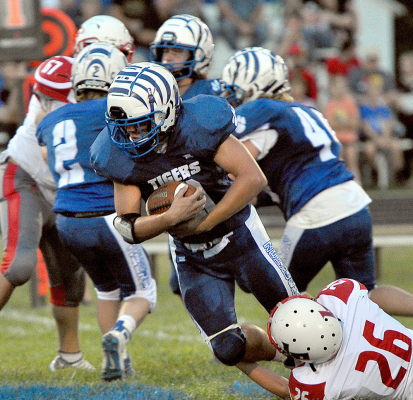 ZACH YOUNG secures the football with both hands as he breaks a tackle during action between the Stockton Tigers and Logan/Palco on September 2 at Tiger Stadium.