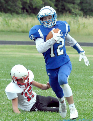 TIGER EIGHTH GRADER HUNTER HOWELL gets by his defender on his way to another big run. Howell scored several touchdowns in Stockton’s 88-56 win over Logan/Palco last Thursday evening at Tiger Stadium.