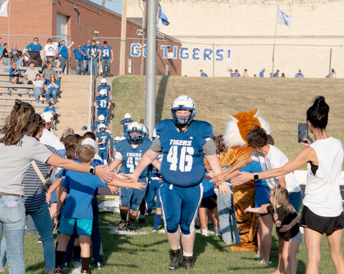 Taylor Inglsbee and his teammates run through the Tiger Tunnel on Homecoming